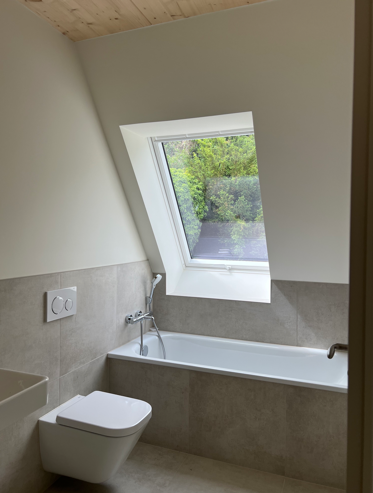 Alte Schlosserei Königstein: Badezimmer im Dachgeschoss mit Badewanne und Dachfenster