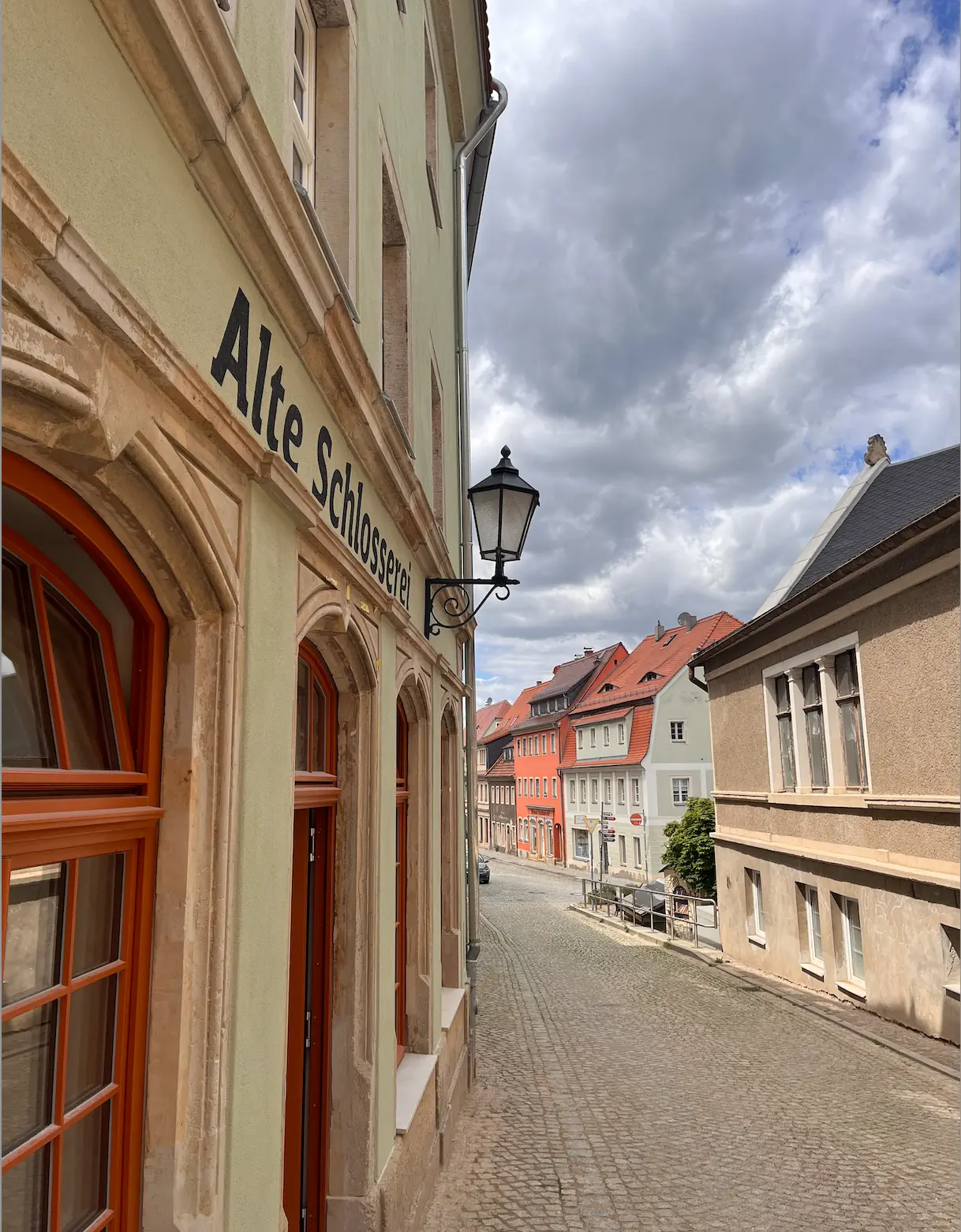 Alte Schlosserei Königstein: sanierte Straßenfassade mit Schriftzug und Laterne